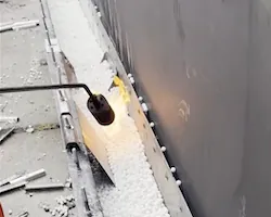 Firefighters run a torch flame along a tank rim seal packed with Dryfoam beads